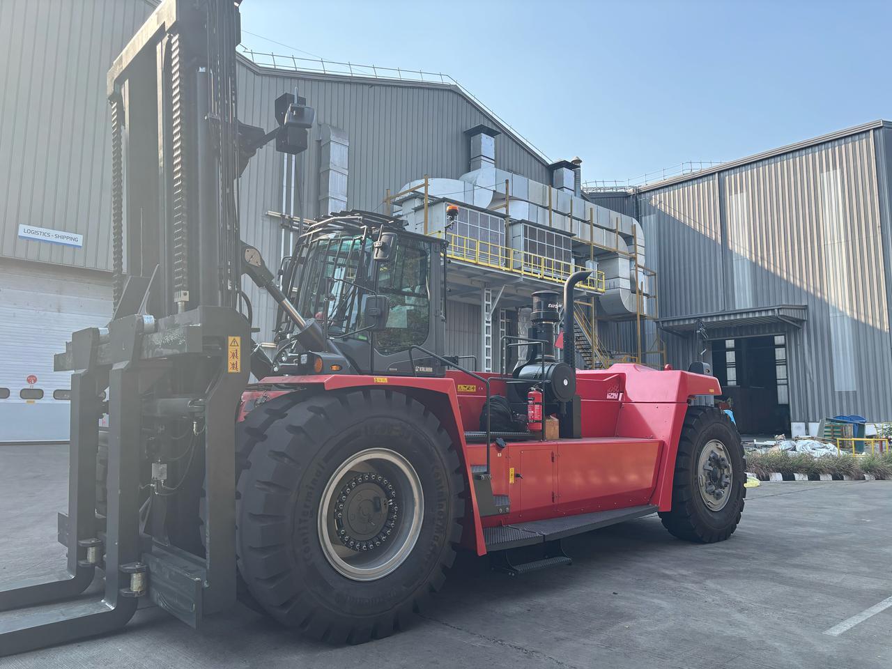 A Kalmar reach stacker staged outside the logistics and shipping bay